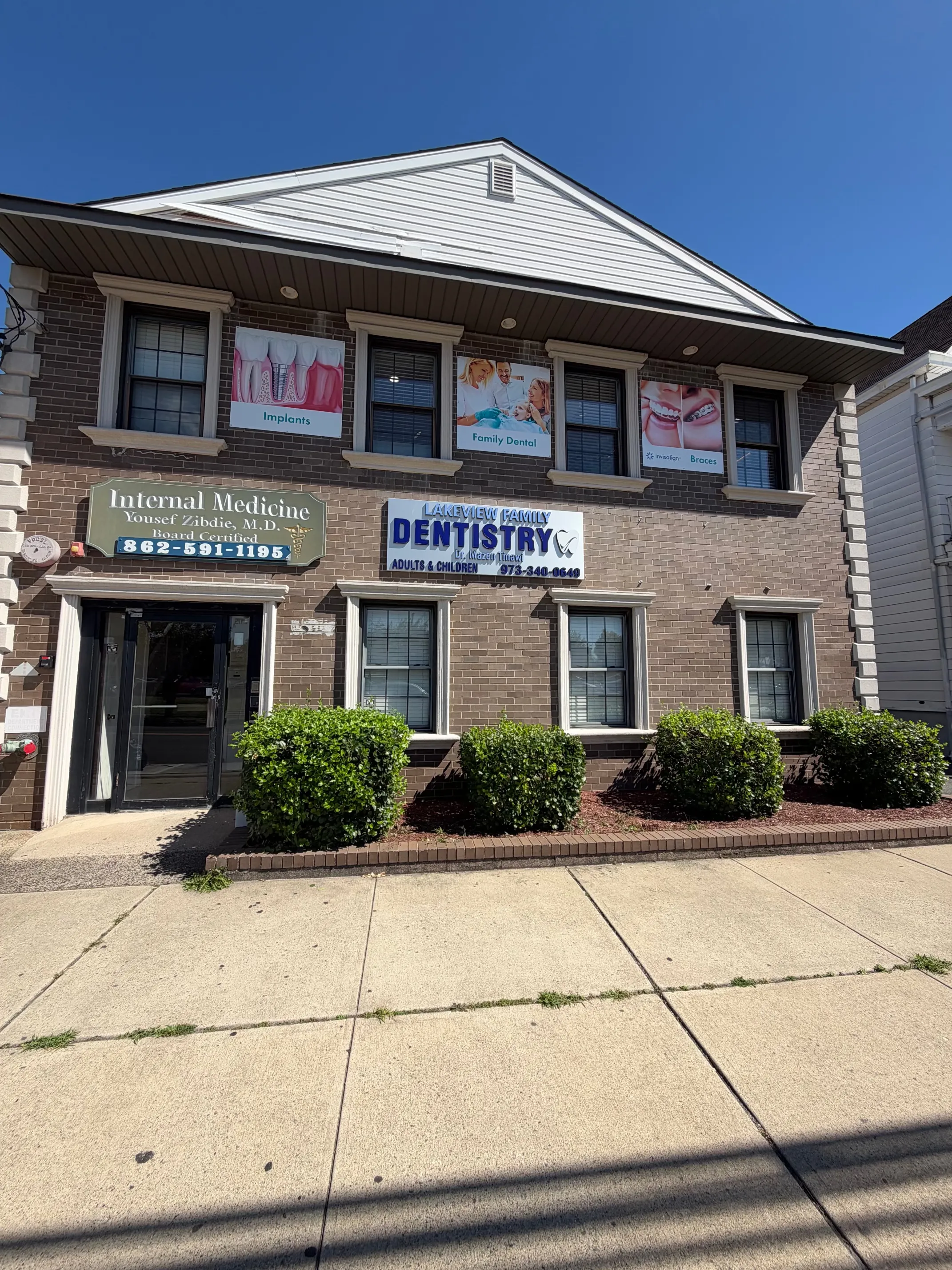The brick front of the building on Lakeview Avenue, with the Lakeview Family Dentistry sign and second-floor window banners for implants, family dental and braces.