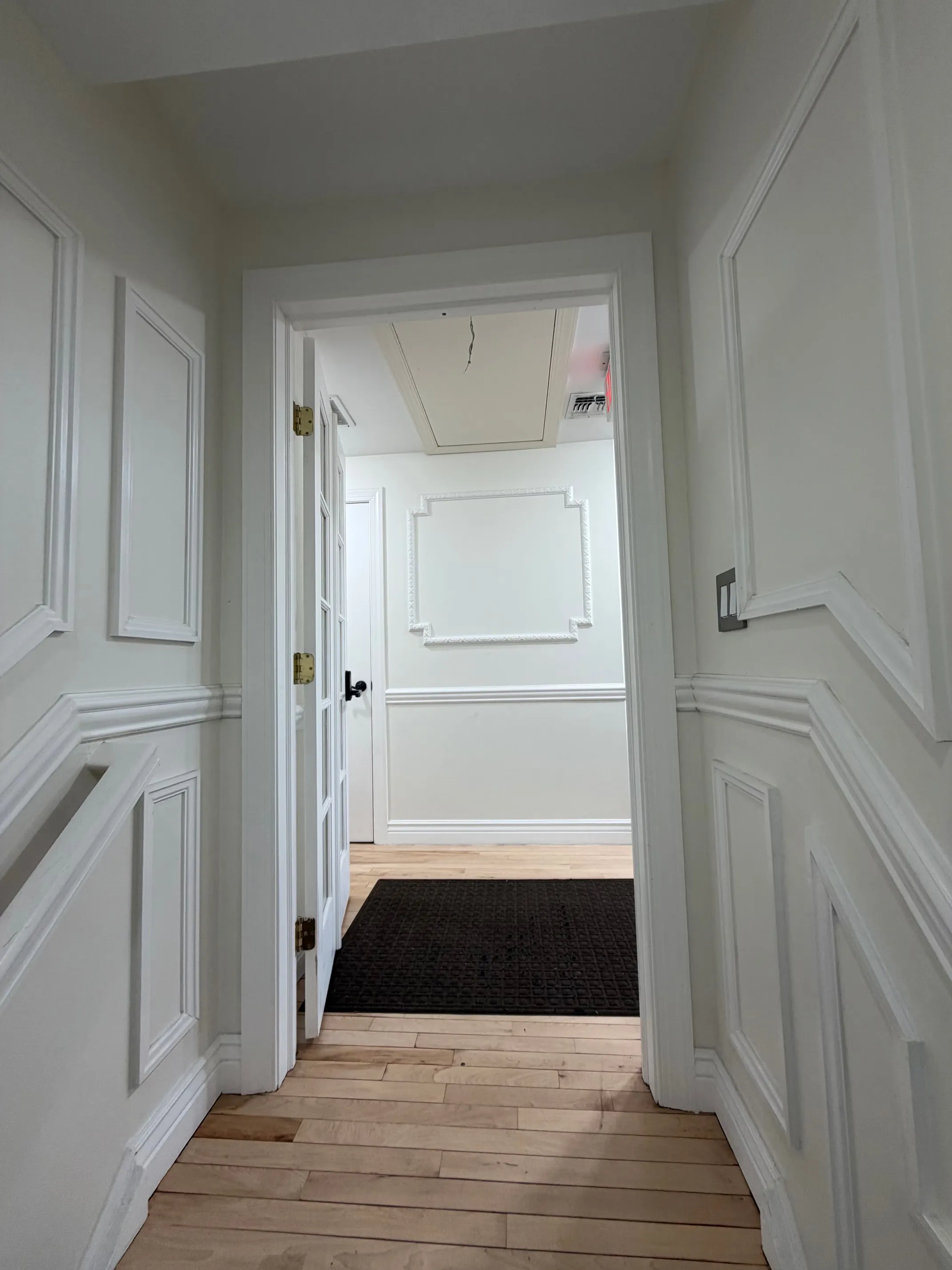 The second-floor landing, with wainscoted walls and the open door into the office.