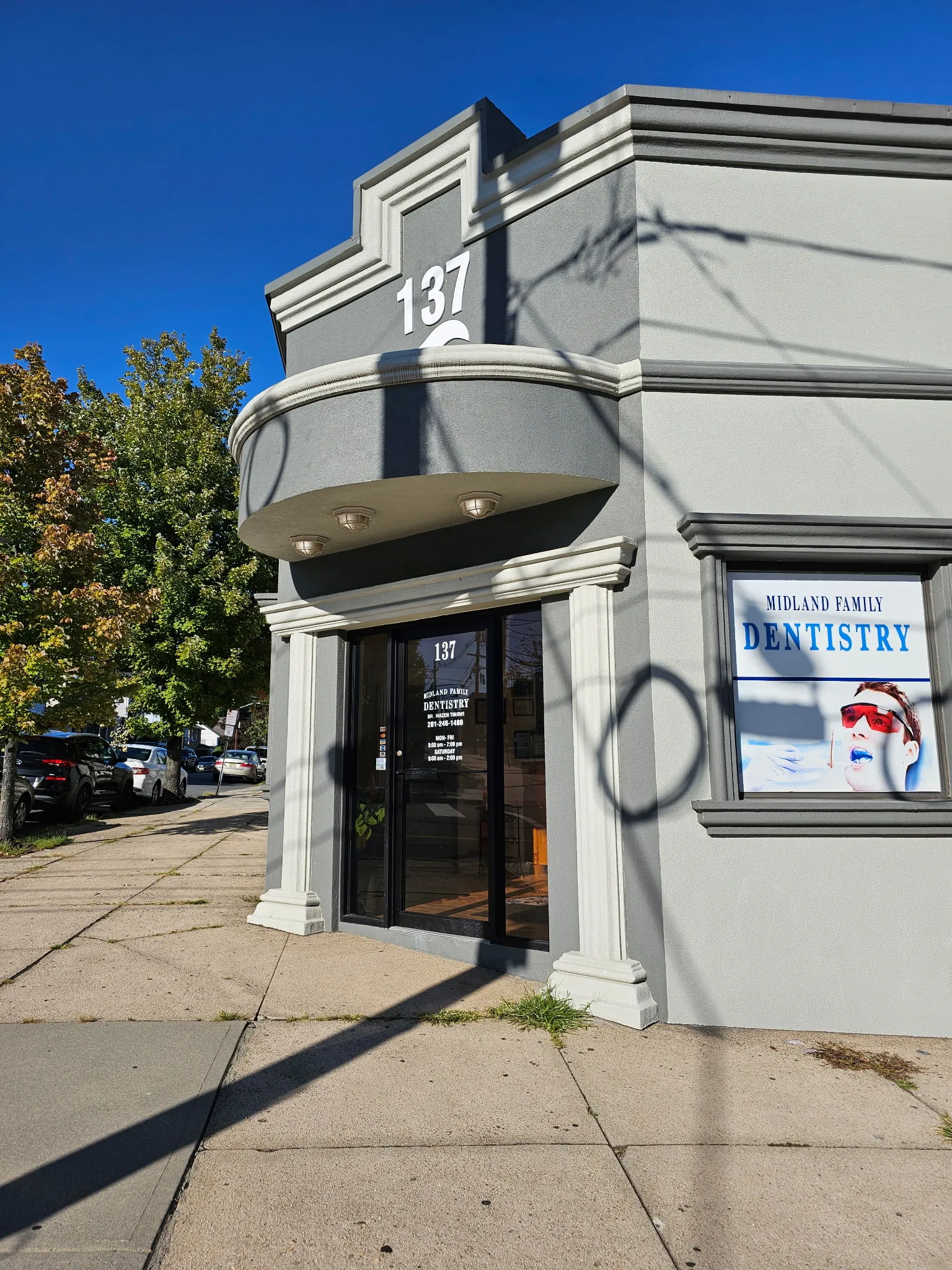 The practice from the street corner, with the Midland Family Dentistry window sign and a maple tree at the kerb.