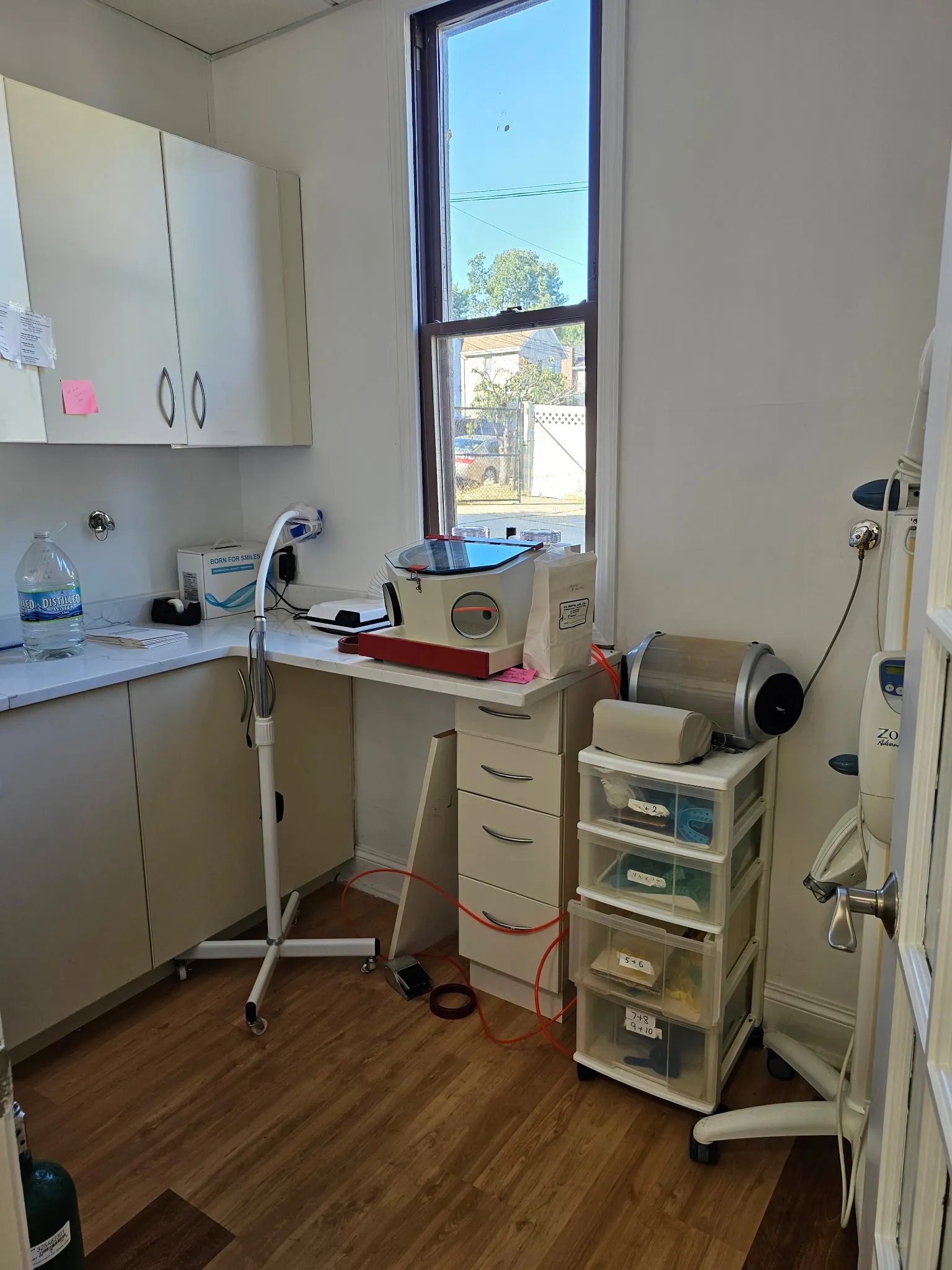 The on-site lab, with a sandblasting cabinet, model trimmer and trays of aligner cases by the window.